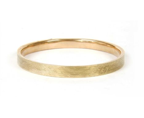 A 9ct gold hollow bangle, ( damaged ) with engine turned decoration, Birmingham 1929, 10.68g