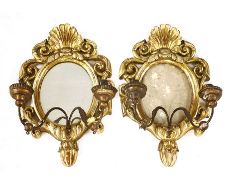 A pair of possibly Irish two-light girandoles, 19th century, each with a shell crest over a pierced and carved scrolling fram