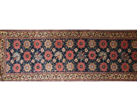 A Persian runner rug, the central panel with scrolling flowerheads on a blue ground within multiple borders with scrolling fo