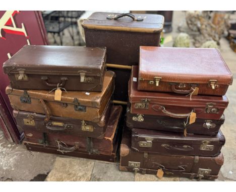 A collection of leather suitcases and a steamer trunk 