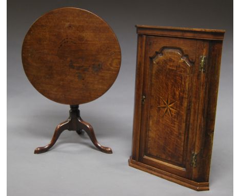 An oak circular tilt top table, 19th century, on tripod base, 114 cm high x 77 cm diam.; together with an oak corner cabinet,