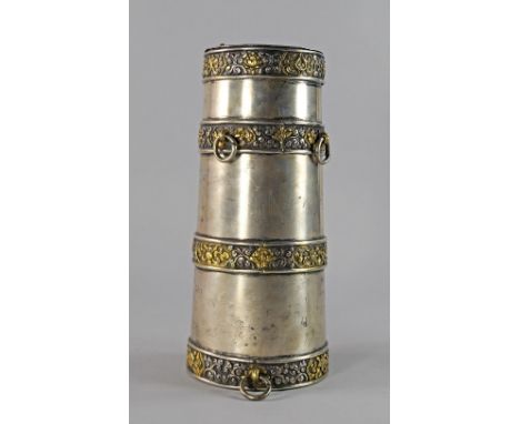 A Tibetan white metal and gilt powder flask, of spreading form with various suspension loups, applied with bands of stylised 