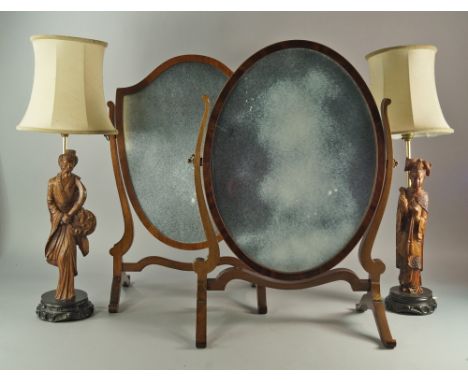 An Edwardian oval dressing table mirror, with shaped support on scroliing feet, 58cm high, together with another shield shape