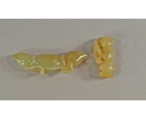 A Chinese jade model of a boy, late 19th/20th century, modelled holding a lotus branch, 4cm high, together with a jade model 