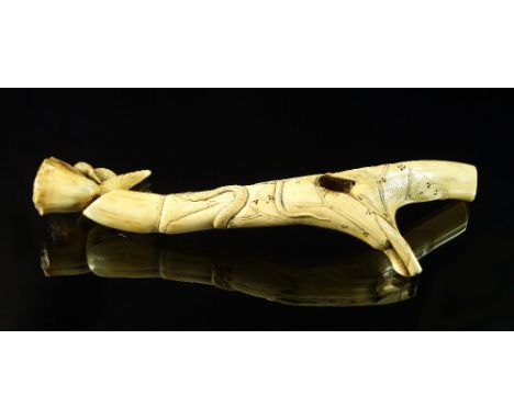 A Japanese carved antler pipe piece, 19th century, decorated in the round with a bird and foliage, 26 cm high, (a/f). 
