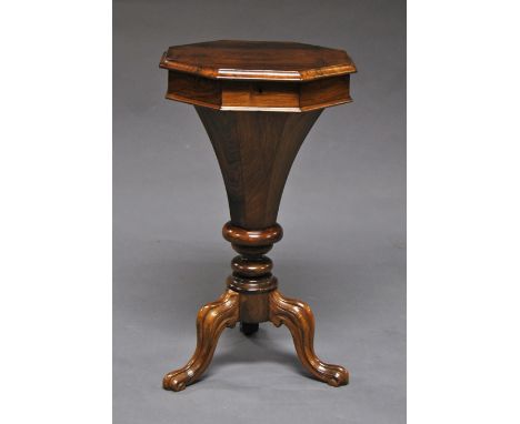 A Victorian rosewood work table, the octagonal top opening to reveil fitted interior, raised on tripod legs, 72cm high x 41cm