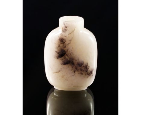 A Chinese pale white jade snuff bottle, late 19th century, verso with dark band, raised on cylindrical foot, 6 cm high.  