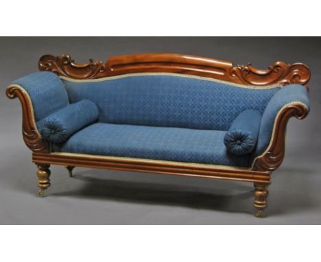 A Victorian mahogany roll top sofa, with blue upholstery, raised on turned legs and castors. 