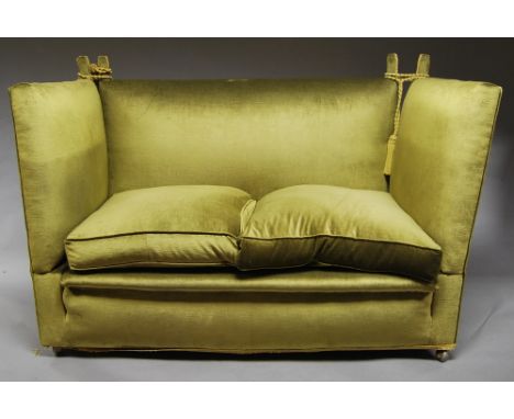 A two seat Knowle sofa, 20th century, upholstered in green velvet, on castors