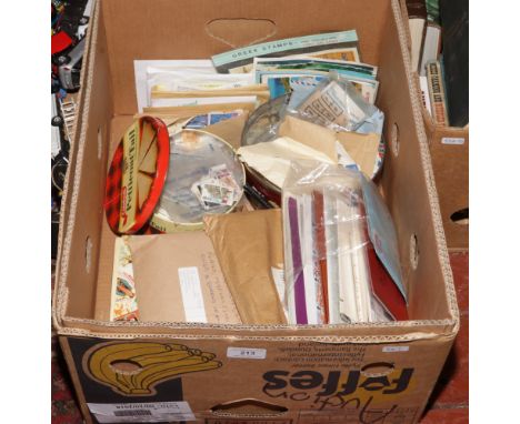 A box lot of loose stamps, postcards and postal ephemera along with a globe masters stamp album and an encyclopedia of World 