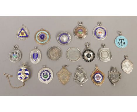 A collection of silver medals and badges to include enamel examples.