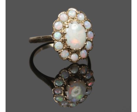 A 9ct gold opal cluster ring assayed London 1976, size O.Condition report intended as a guide only.Centre stone good. Outer s