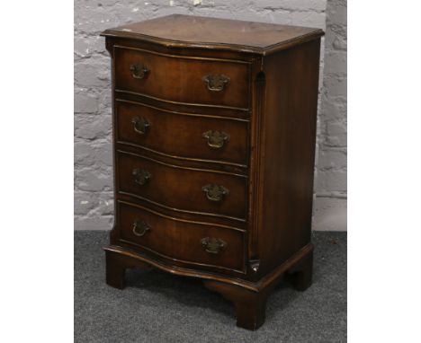A miniature burr walnut chest of four serpentine drawers, cross banded in mahogany and raised on bracket feet, 50cm width, 38
