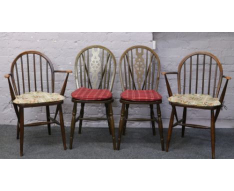 A pair of Ercol spindle back arm chairs, along with a pair of wheel back dining chairs.