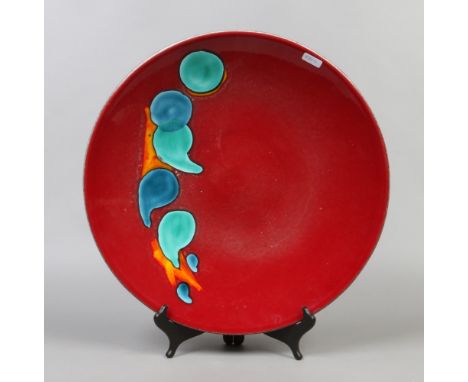 A Poole charger, red glazed and decorated in the Odyssey design, 40cm .