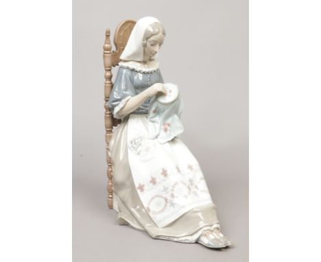 A large Lladro figure of a seated maiden embroidering, approximate height 28cm&nbsp;Condition report intended as a guide only