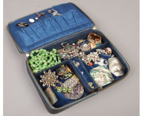 A black ostrich skin dressing case containing mixed costume jewellery including stick pins, white paste and Scottish examples