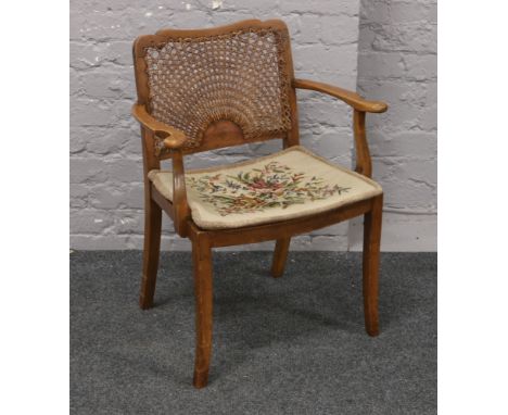 A mahogany bergere seat and back arm chair with woolwork floral cushion.