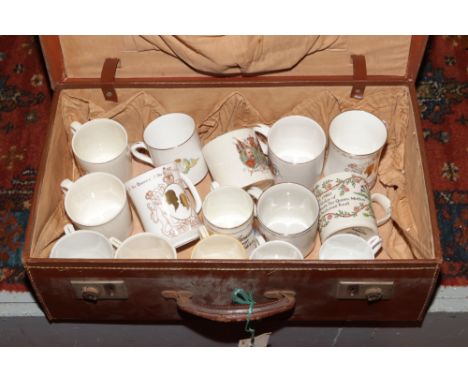 A vintage suitcase with contents of commemorative ceramic mugs to include Staffordshire, Boncath pottery, Marcus Adams exampl