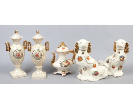 A pair of Staffordshire ceramic mantle dogs decorated with fruit along with a matching ornamental tea pot and a pair of Empir