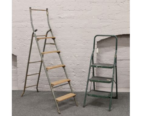 Two sets of folding steel step ladders.