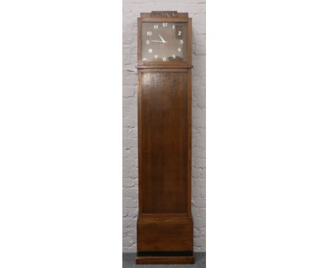 An Edwardian oak long case clock refitted as a bookcase with quartz clock movement.