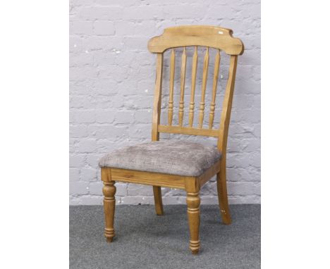 A light oak spindle back chair with upholstered seat.