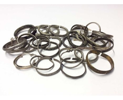 Collection of thirty three Chinese and Eastern white metal and base metal bangles, some with embossed and engraved decoration