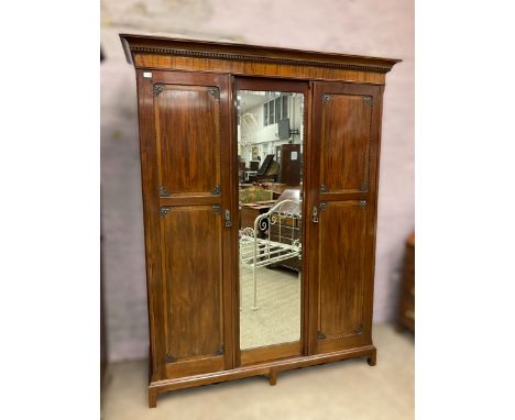 Early 20th century mahogany wardrobe, projecting dentil cornice over central bevelled mirror and two panelled doors, the inte