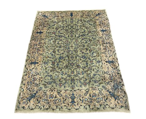 Persian Kashan pale green ground carpet, the field decorated with interlacing branch and stylised flower head motifs, shaped 