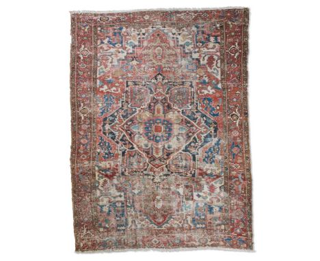 A HERIZ CARPET  With a central medallion on a brick red ground within similar borders  approximately 362cm x 288cm    Conditi