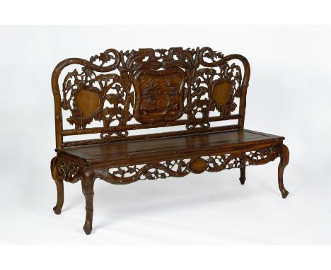 A CARVED HARDWOOD SETTEE The back decorated with birds and flowering foliage, a central carved panel and bamboo carved frame 