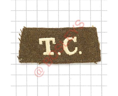 Badge. T.C. scarce Tank Corps WW1 slip-on shoulder title. White embroidered on khaki VGC Cloth tape 