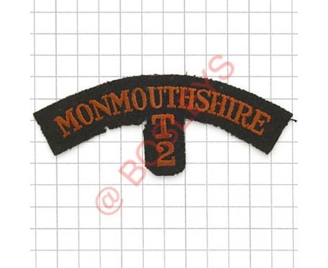 Badge. MONMOUTHSHIRE / T / 2 scarce WW1 Welsh embroidered shoulder title. Red on green. Some moth 