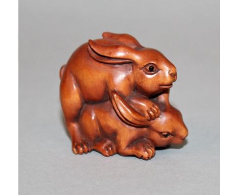 A SIGNED JAPANESE NETSUKE OF TWO RABBITS, 1.9in long & 1.5in high.