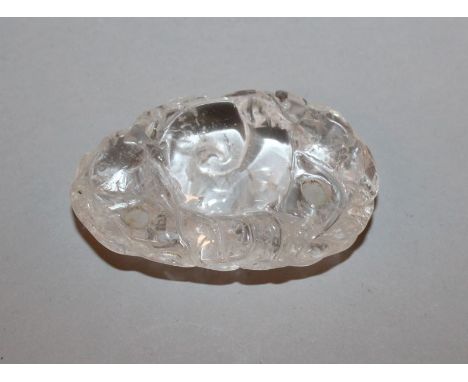 A CHINESE ROCK CRYSTAL PEBBLE-FORM CARVING, possibly a scroll weight, the surface carved in shallow relief with lingzhi, 3in 