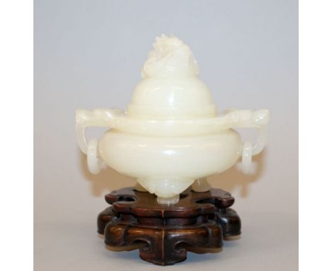A CHINESE JADE-LIKE TRIPOD CENSER & COVER, together with a fitted wood stand, the sides with double dragon-head and loose rin