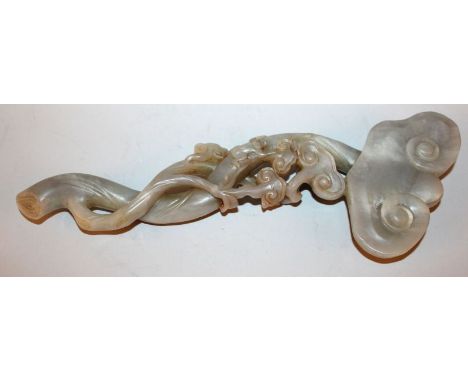 A CHINESE JADE SCEPTRE, the sinuous stem carved with a clambering monkey and lingzhi fungus, the stone of a predominantly gre