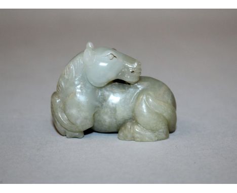 A GOOD QUALITY 19TH/20TH CENTURY CHINESE JADE MODEL OF A HORSE, the seated animal with his head turned backwards over its bod