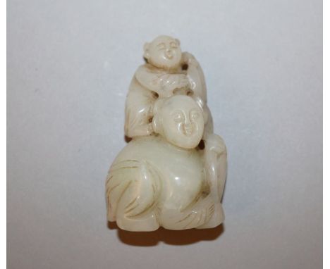 A 19TH CENTURY CHINESE CELADON JADE CARVING OF TWO BOYS, one crouching and supporting the smaller boy on his shoulders, 2.3in