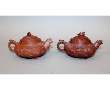 A GOOD PAIR OF 17TH/18TH CENTURY MOULDED ZISHA YIXING POTTERY TEAPOTS & COVERS, circa 1690, the sides of each moulded with tw