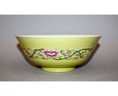 A CHINESE YELLOW-GROUND FAMILLE ROSE PORCELAIN BOWL, the sides moulded in relief with a narrow band of scrolling foliage, the