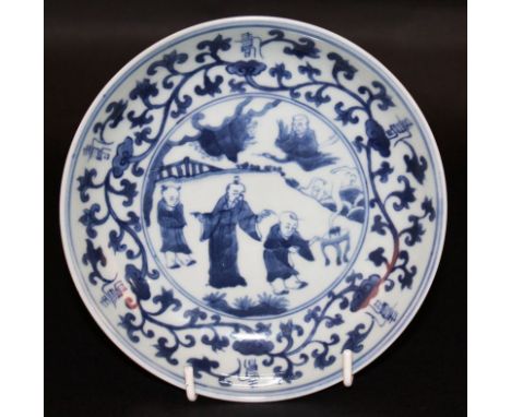 A CHINESE BLUE & WHITE PORCELAIN DISH, decorated to its centre with a scene of a sage and attendants in a fenced garden setti