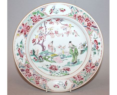 A CHINESE YONGZHENG PERIOD FAMILLE ROSE PORCELAIN PLATE, painted to its centre with two figures in a garden setting, 9in diam