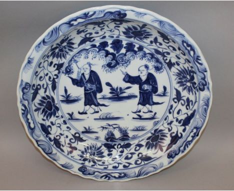 A LARGE GOOD QUALITY CHINESE BLUE & WHITE PORCELAIN CHARGER, with wavy rim, the centre painted with two boys in a garden sett