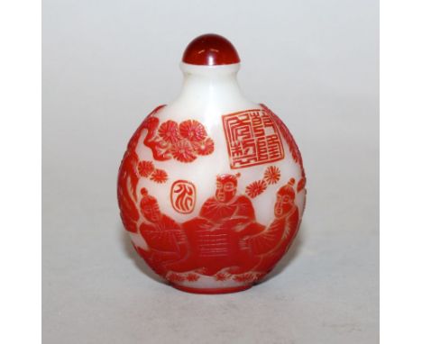 A CHINESE RED OVERLAY GLASS SNUFF BOTTLE & STOPPER, decorated in shallow relief with figures playing go, the scene reserved o