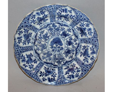 A CHINESE KANGXI PERIOD BLUE & WHITE MOULDED PORCELAIN PLATE, circa 1700, painted with a profusion of floral lappet panels, t