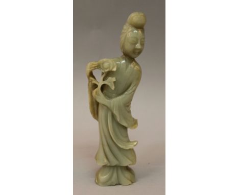 A GOOD QUALITY 19TH CENTURY CHINESE CARVED CELADON JADE FIGURE OF A LADY, dressed in flowing robes and holding a spray of peo