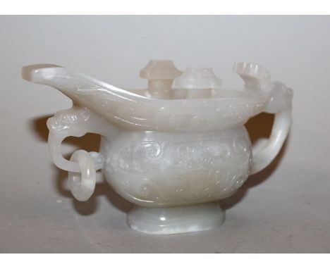 A CHINESE YI FORM JADE-LIKE RITUAL POURING VESSEL, of archaic design and with a loose ring handle to its front, 5in long.