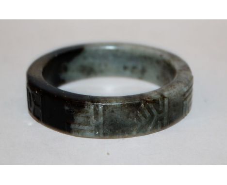 ANOTHER UNUSUAL CHINESE JADE BANGLE, 19th Century or earlier, the stone of predominantly grey-green tone with a large area of